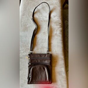 Brown faux leather crossbody. Lots of pockets, carries a  water bottle. One flaw